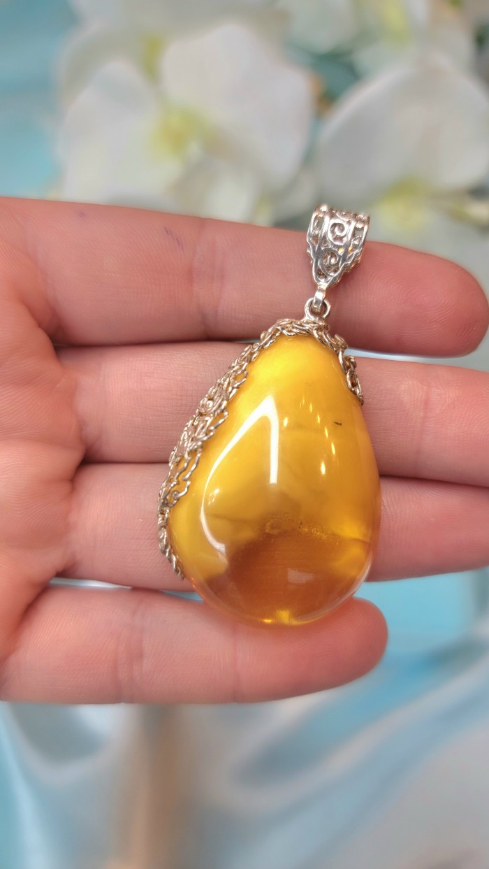 Prehistoric Butterscotch Authentic Baltic Amber .925 Sterling Silver beautifully handcrafted Pendant - Close-up of butterscotch Baltic amber pendant in hand.