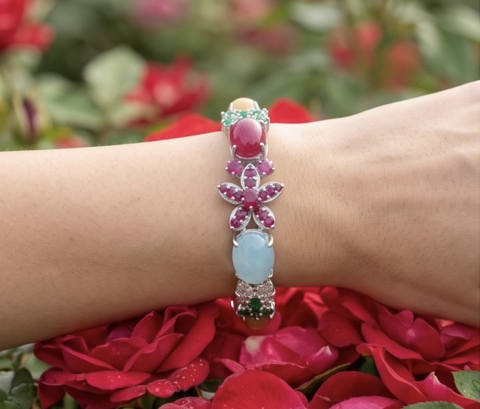 Isabella - Beauty of Nature natural 85.5 carat Ruby Green Tourmaline Rhodium over .925 Sterling Silver handmade Statement bracelet - Bracelet with colorful stones, worn on wrist, red roses in background.