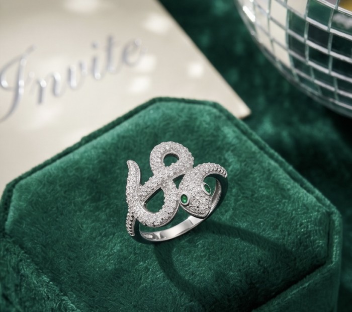 Precious Boa Snake Genuine Emerald White Topaz .925 Sterling Silver handcrafted Ring s. 8 - Top view of snake-shaped ring with emerald eyes on green velvet background.