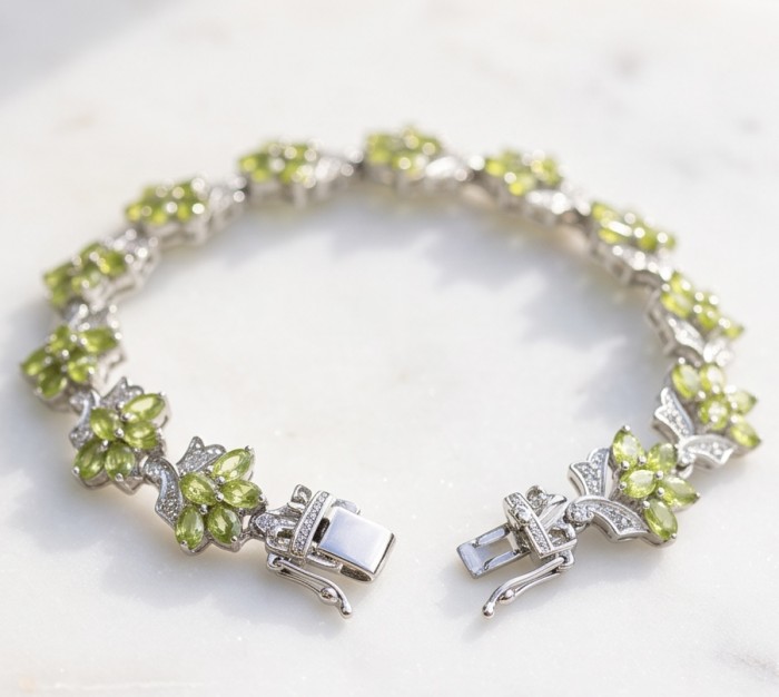 Vittoria Natural 29.8 carat Brazilian Peridot Rhodium over .925 Sterling Silver handmade Statement Bracelet - Bracelet with green peridot stones and clasp detail on white background.
