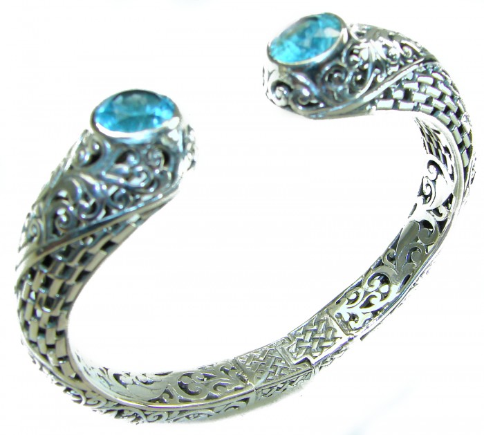 Large and Heavy Bali Legacy 45.5 grams authentic 10.9 carat Swiss Blue topaz Floral Bracelet in .925 Sterling Silver handcrafted - Silver bracelet with blue stones, intricate detailing, angled view.