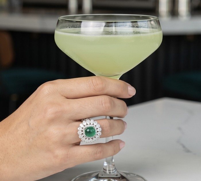 Elizabeth princess cut 4.8 carat Colombian Emerald 8.3 carat Moissanite .925 Sterling Silver dipped in Rhodium handcrafted Ring size 5 1/4 - Emerald ring with diamonds worn on hand, holding a cocktail glass