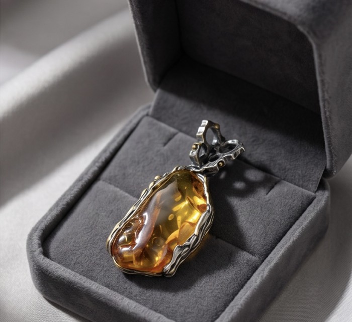 Massive Prehistoric Authentic Golden Baltic Amber rhodium over .925 Sterling Silver beautifully handcrafted Pendant - Amber pendant in a dark case, top view displaying stone and setting.