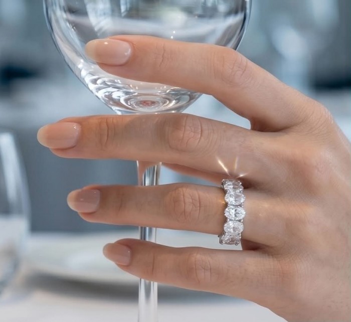 Luxurious 6.5 carat White Topaz .925 Sterling Silver infinity ring size 6 3/4 - Hand wearing luxurious 6.5 carat topaz ring holding a wine glass