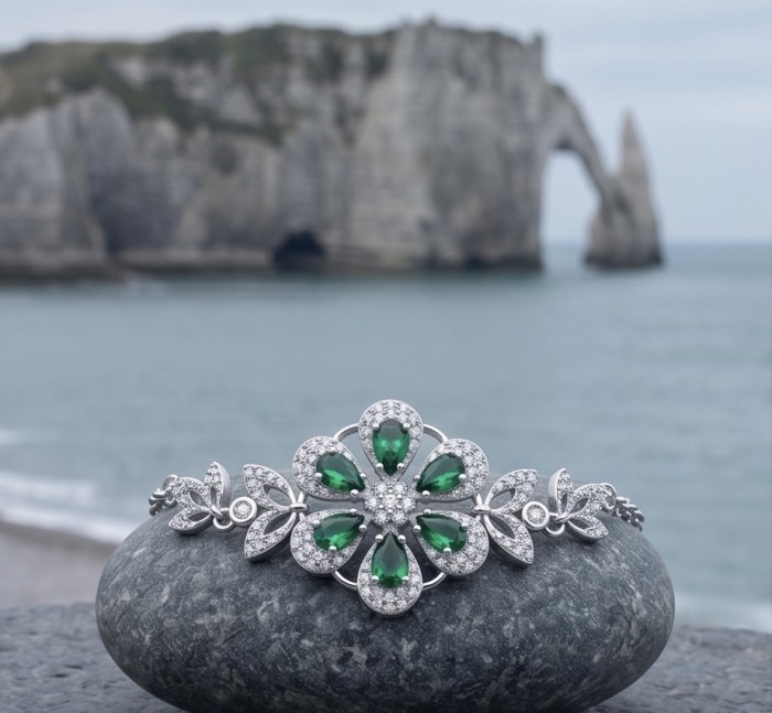 Giovanna - Authentic 7.9 carat Colombian Emerlad .925 Sterling Silver handcrafted Statement bracelet - Front view of emerald and silver bracelet on rock by the sea.