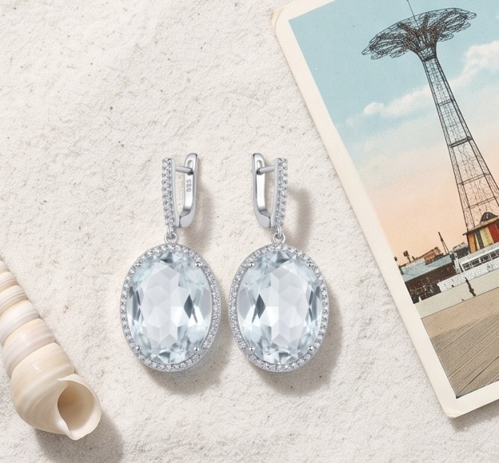 Angelina 14.9 carat authentic White Topaz .925 Sterling Silver Handcrafted Earrings - Earrings front view on sand with seashell and postcard background