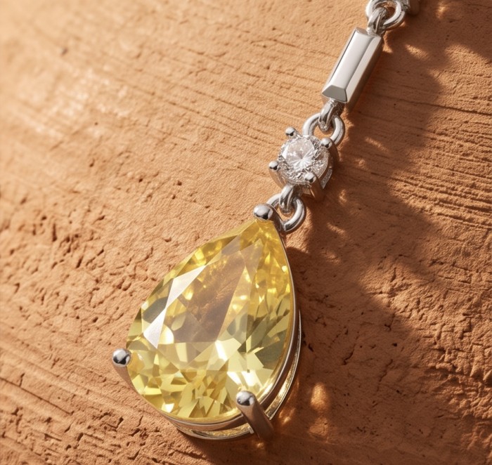 Luxurious pear cut 8.5 carat Yellow Sapphire rhodium over .925 Sterling Silver handcrafted earrings - Close-up of pear cut yellow sapphire pendant on textured background