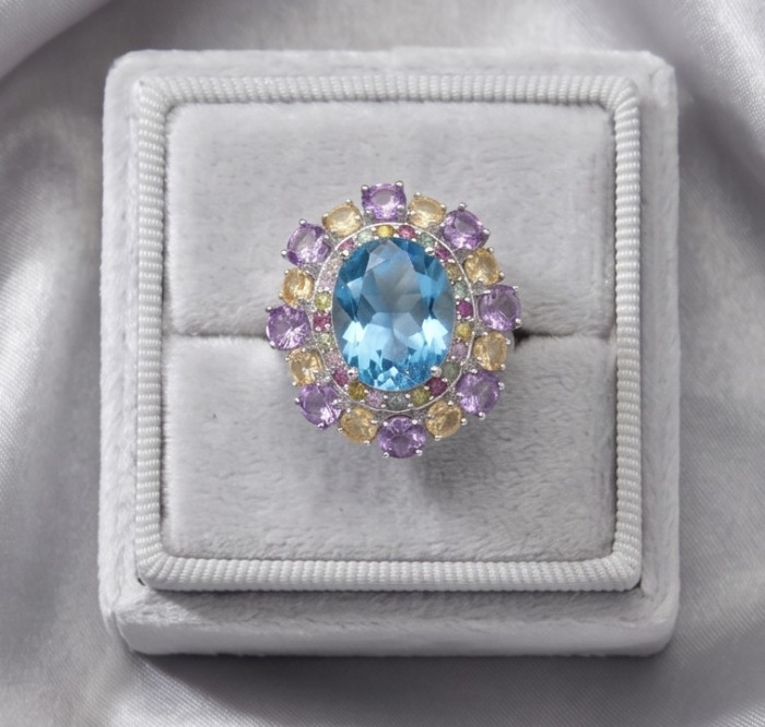 Pacifica - Authentic 33.8 carat Swiss Blue Topaz Rhodium over .925 Sterling Silver handcrafted Large Statement ring size 7 - Top view of blue topaz ring with purple and yellow stones in a box.