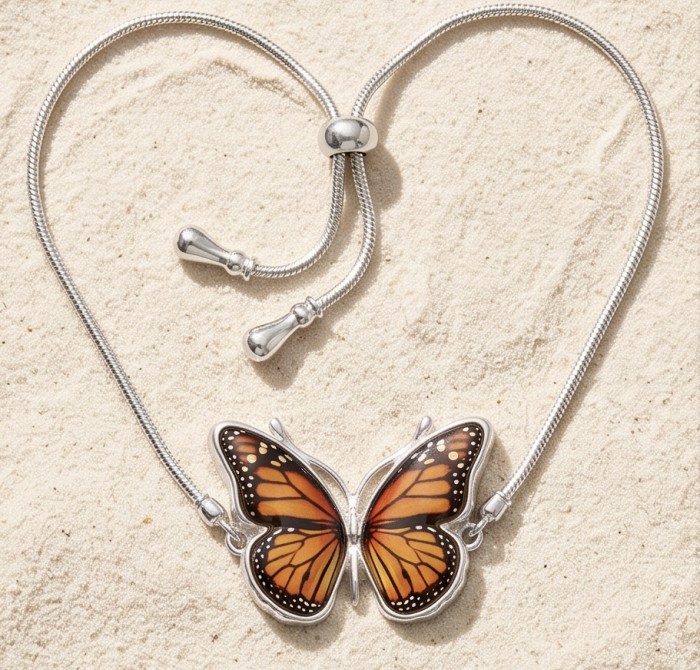 Golden Butterfly Genuine carved Baltic Amber rhodium over .925 Sterling Silver handamde Bracelet - Top view of butterfly amber necklace on sandy background