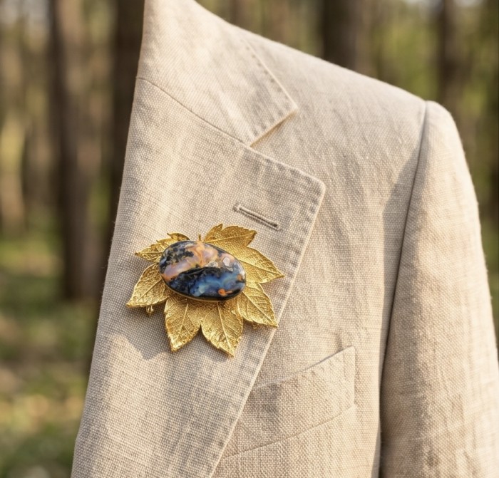 Stylish REAL Leaf dipped in 14K Gold 24.5 CARAT Boulder Opal .925 Sterling Silver Pendant - Gold leaf and opal brooch on beige jacket lapel, frontal view.