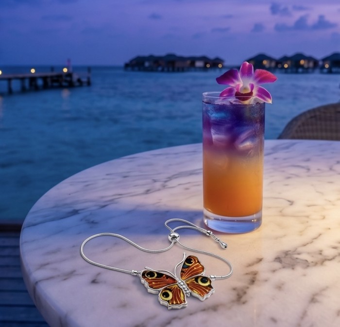 Golden Butterfly Genuine carved Baltic Amber .925 Sterling Silver handamde Bracelet - Golden Butterfly necklace on table with gradient drink, ocean in background