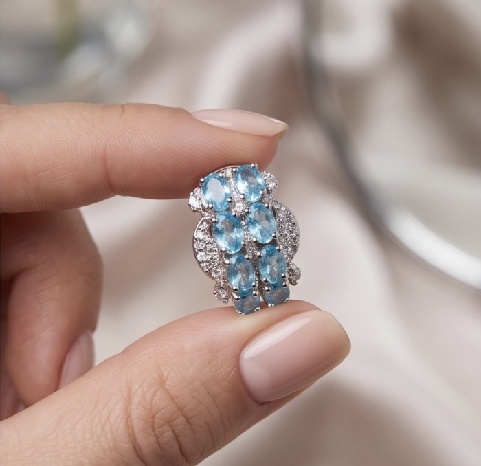 Angelina 9.9 carat authentic Swiss Blue Topaz .925 Sterling Silver Handcrafted Earrings - Close-up of Swiss Blue Topaz ring held between fingers