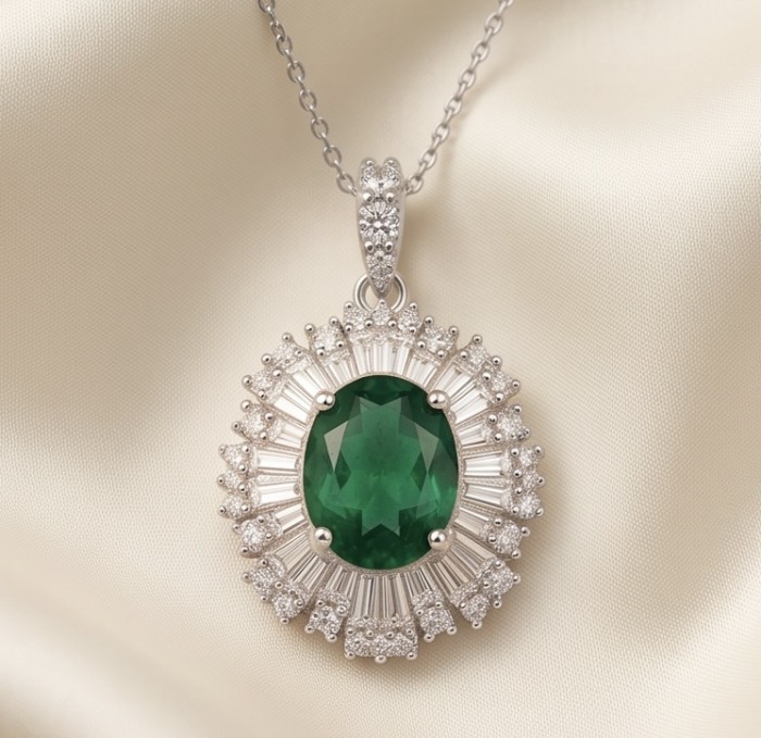 The Green Queen Natural 18.5 carat Emerald Moissanite .925 Sterling Silver handcrafted Necklace - Emerald Moissanite pendant on chain, top view on fabric background.