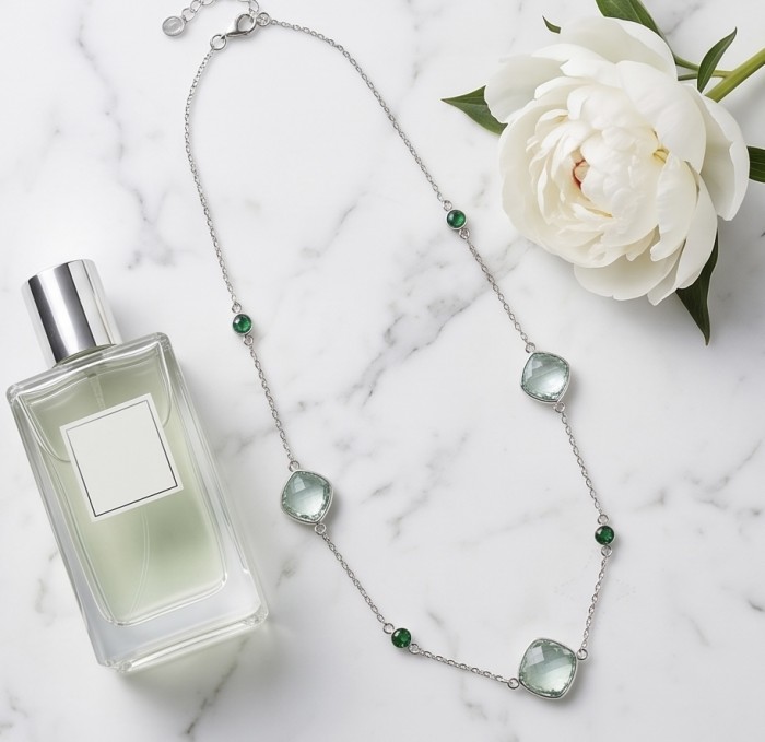Infinity 18.5 carat Authentic Multigems Rhodium over .925 Sterling Silver handcrafted Statement necklace - Necklace side view with perfume bottle and flower on marble background.