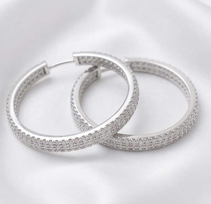 INSIDE - OUT Huge 1 3/8 inches long White Topaz rhodium over .925 Sterling Silver handmade Hoop Earrings - Side view of large hoop earrings with white topaz stones on fabric background