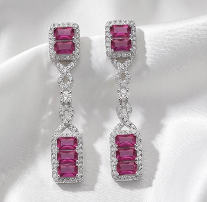 Art Deco - Giovanna - Magnificent Jewel 6.5 carat Ruby .925 Sterling Silver handcrafted incredible earrings - Dangling art deco ruby earrings on satin background, frontal view.
