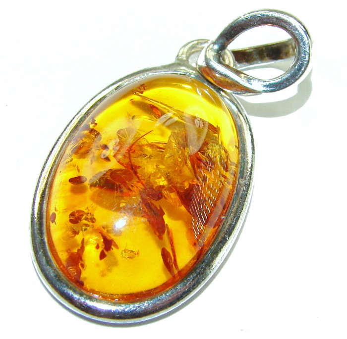 Prehistoric Authentic Baltic Amber .925 Sterling Silver handcrafted Pendant - Amber pendant with insects, sterling silver setting, close-up.