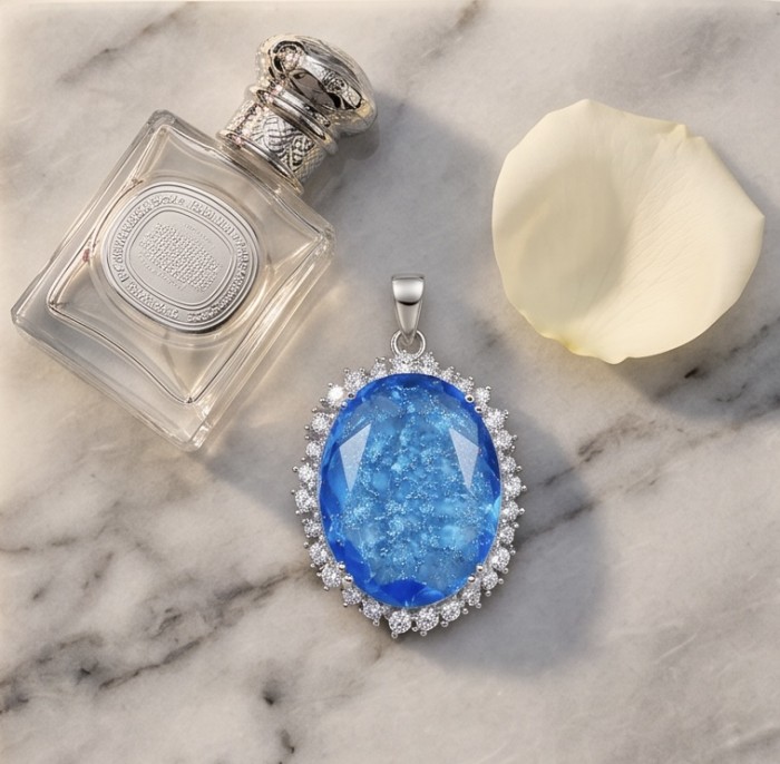 Angelina 10.9 carat authentic Swiss Blue Topaz .925 Sterling Silver Handcrafted handmade Pendant - Blue topaz pendant on marble with perfume and petal, top view.