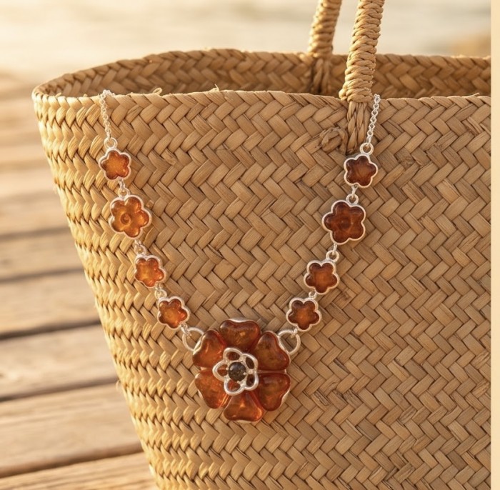 Floral design - natural Golden carved Baltic Amber .925 Sterling Silver handcrafted necklace - Amber floral necklace on woven basket, sunny outdoor setting
