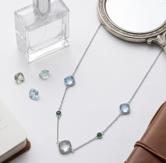 Infinity 8.5 carat Authentic Multigems Rhodium over .925 Sterling Silver handcrafted Statement necklace - Top view of Infinity multigem necklace near perfume and mirror.