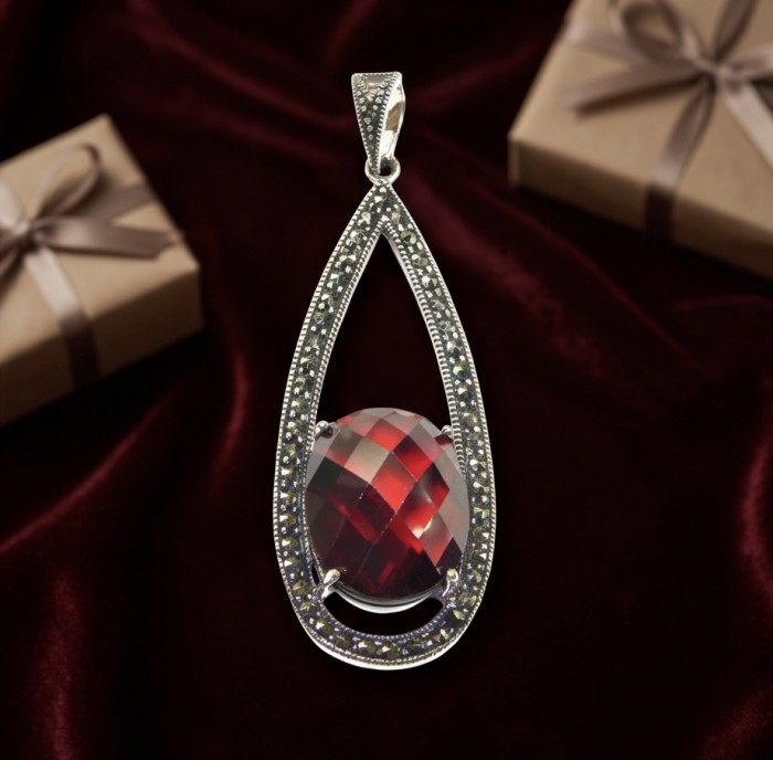Vintage Beauty 17.9 carat genuine Garnet rhodium over .925 Sterling Silver handcrafted pendant - Teardrop pendant with garnet stone on velvet background, top angle view.