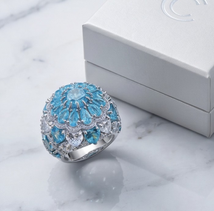Blue Cascade Natural 14.8 carat Swiss Blue Topaz .925 Sterling Silver dipped in rhodium handmade Large Statement Ring size 7 1/4 - Blue topaz ring close-up with decorative box on marble surface.