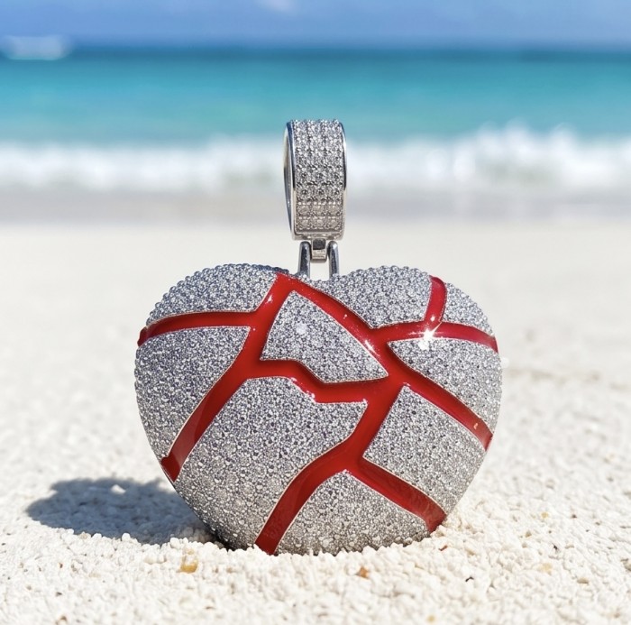 Lava Heart Luxurious 8.4 carat White Topaz .925 Sterling Silver handcrafted pendant - Heart-shaped pendant on sand with beach backdrop, front view close-up.
