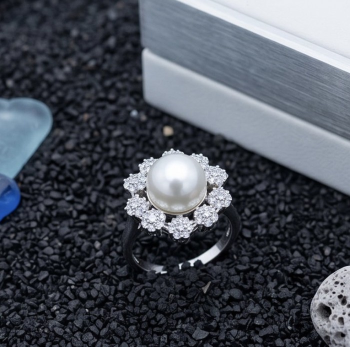 Authentic rare Freshwater Pearl .925 Sterling Silver handcrafted ring; s. 8 - Pearl ring with diamond halo on black stones background, top view.