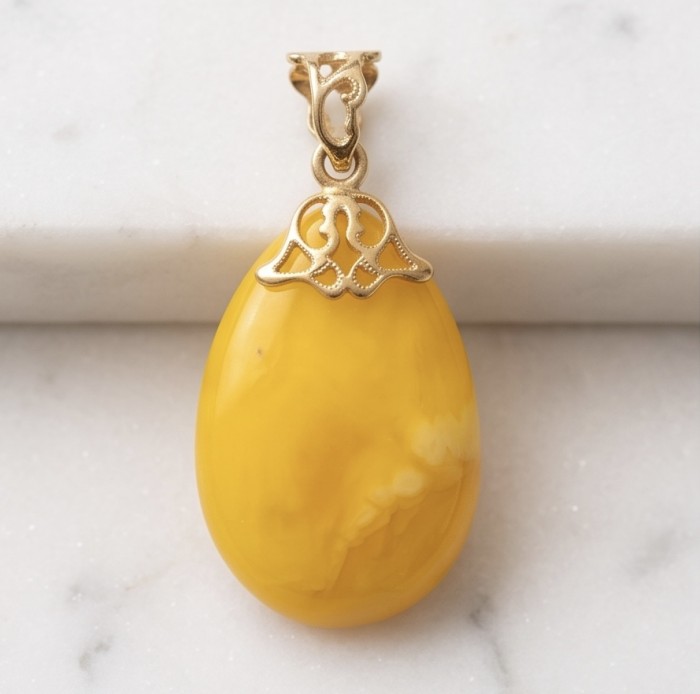 Prehistoric Authentic Baltic Amber REAL 14k Gold beautifully handcrafted Pendant - Close-up of Baltic amber pendant with 14k gold detail on marble surface.