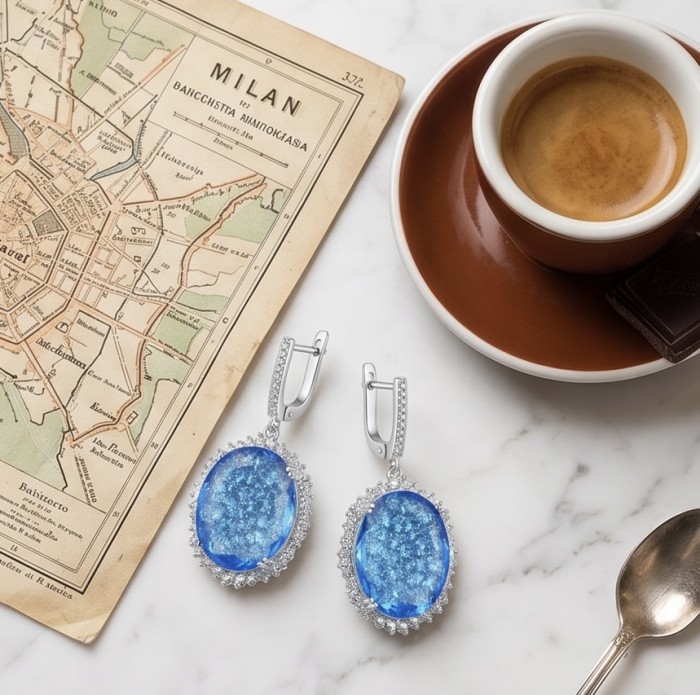 Angelina 14.9 carat authentic Swiss Blue Topaz .925 Sterling Silver Handcrafted Earrings - Swiss Blue Topaz earrings on marble with map and espresso, top view.
