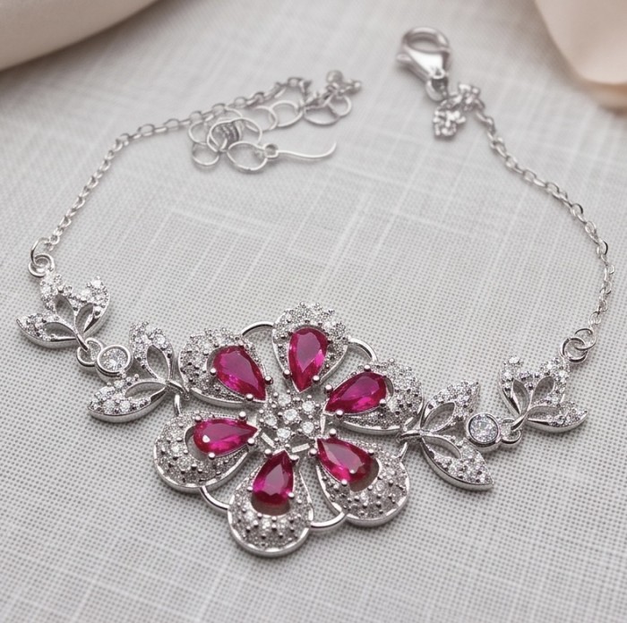 Izabella Luxurious natural 7.5 carat Ruby rhodium over .925 Sterling Silver handmade Bracelet - Ruby bracelet with floral design, top view, showing clasp and chain detail.