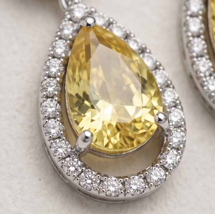 Luxurious pear cut 8.5 carat Yellow Sapphire rhodium over .925 Sterling Silver handcrafted earrings - Close-up of pear cut Yellow Sapphire with diamond halo setting