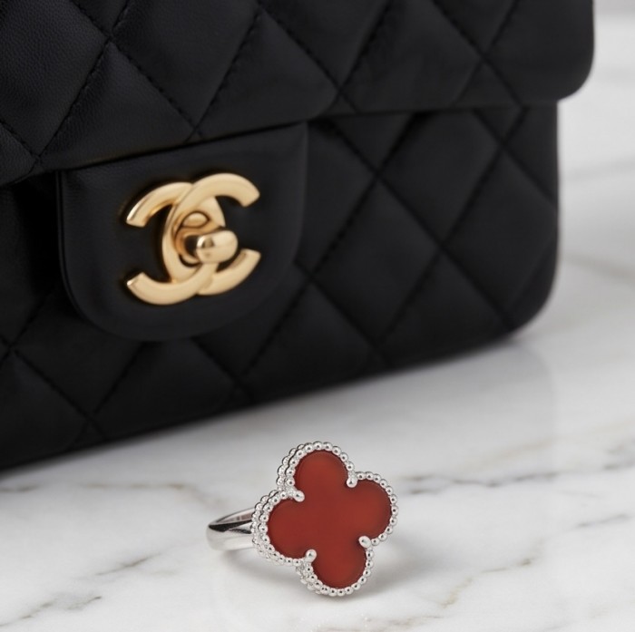 A four-leaf clover Coral .925 Sterling Silver handcrafted ring s. 6 1/4 - Four-leaf clover coral ring close-up with Chanel bag backdrop.