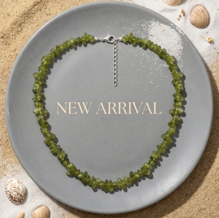 Melissa - Great Masterpiece 45.7 carat genuine Brazilian Peridot .925 Sterling Silver handmade Statement necklace - Green gemstone necklace on plate with sand and shells, top view.
