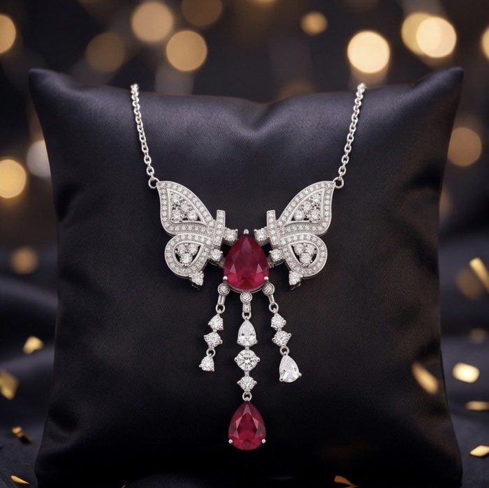 Giovanna - Magnificent Jewel 6.8 carat Ruby .925 Sterling Silver handcrafted incredible Statement Necklace - Close-up of butterfly-shaped ruby necklace on black cushion.