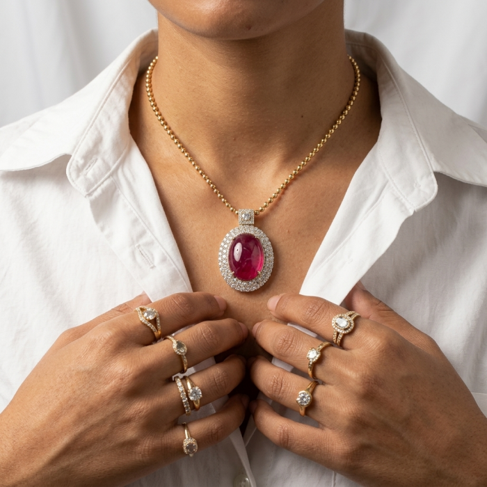 Rare finding! Deluxe 27.2 carat authentic Kashmir Ruby rhodium over .925 Sterling Silver handmade Statement Pendant - Close-up of deluxe Kashmir Ruby necklace and multiple rings worn on hands.