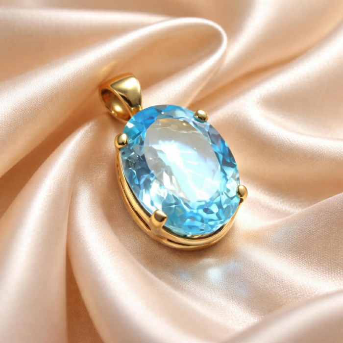Atlantica oval cut 22.9 carat Swiss Blue Topaz 18K Gold over .925 Sterling Silver Handcrafted Pendant - Close-up of Atlantica oval Swiss Blue Topaz pendant on soft fabric