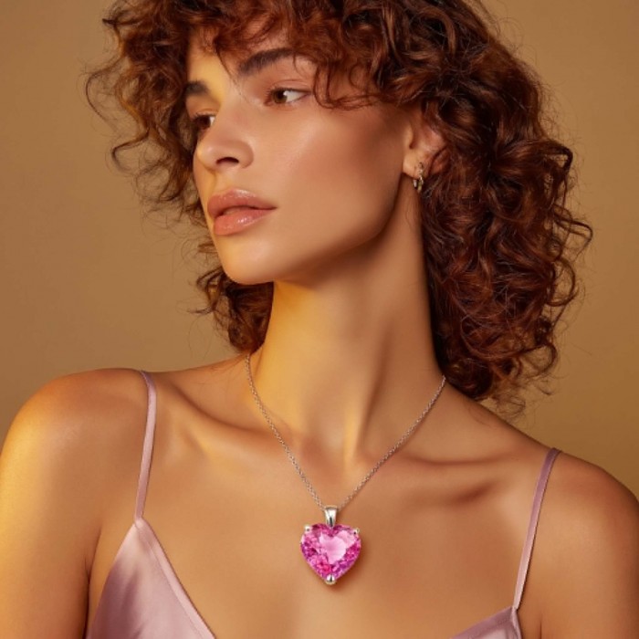 Angel's Heart Luxurious 26.8 carat Pink Sapphire .925 Sterling Silver handcrafted pendant - Side view of woman wearing Angel's Heart pink sapphire necklace