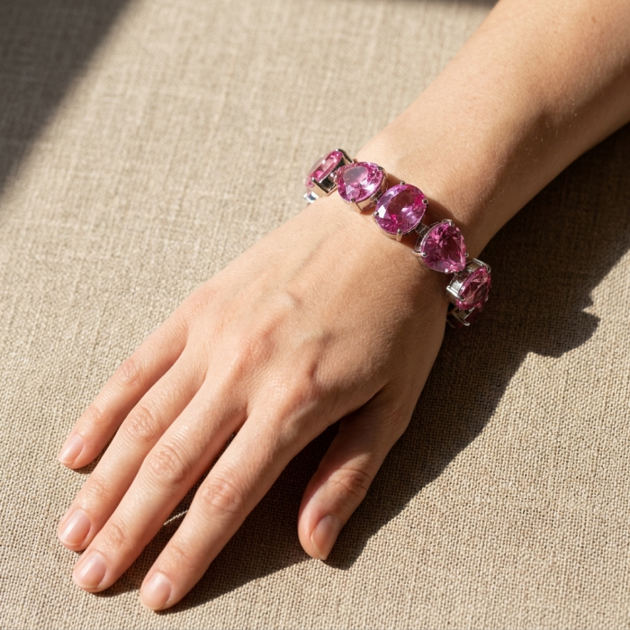 Luxurious 158.4 carat Fuchsia Pink Sapphire .925 Sterling Silver handcrafted Bracelet - Sapphire bracelet worn on a hand, fuchsia pink stones in sunlight.