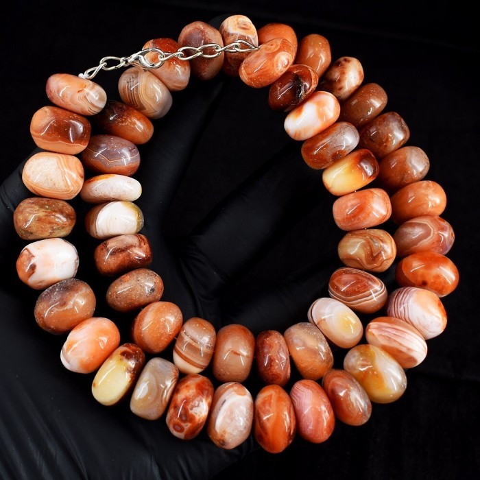 Carnelian - acting as a talisman to banish fear and inspire action - Natural 887.4 Cts Carnelian Agate .925 Sterling Silver MASSIVE Necklace - Carnelian stone beads close-up, held in a gloved hand.