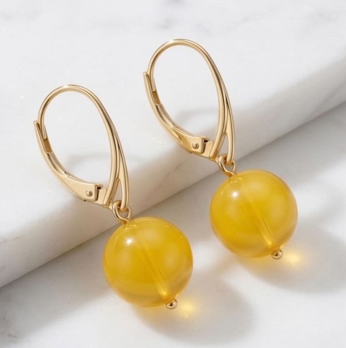 Very Special product - Wonderful Butterscotch Baltic Amber .925 Sterling Silver DIPPED IN 14k Gold entirely handcrafted earrings - Close-up of gold earrings with butterscotch Baltic amber spheres.