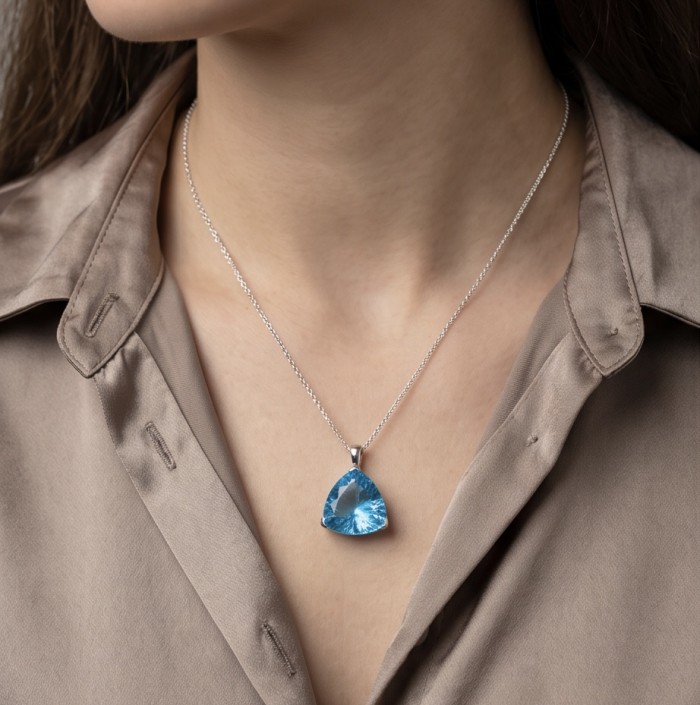 Trillion cut 21.2 carat Vintage style Swiss Blue Topaz .925 Sterling Silver DIPPED IN RHODIUM handmade Pendant - Woman wearing Swiss Blue Topaz necklace, close-up on chest.