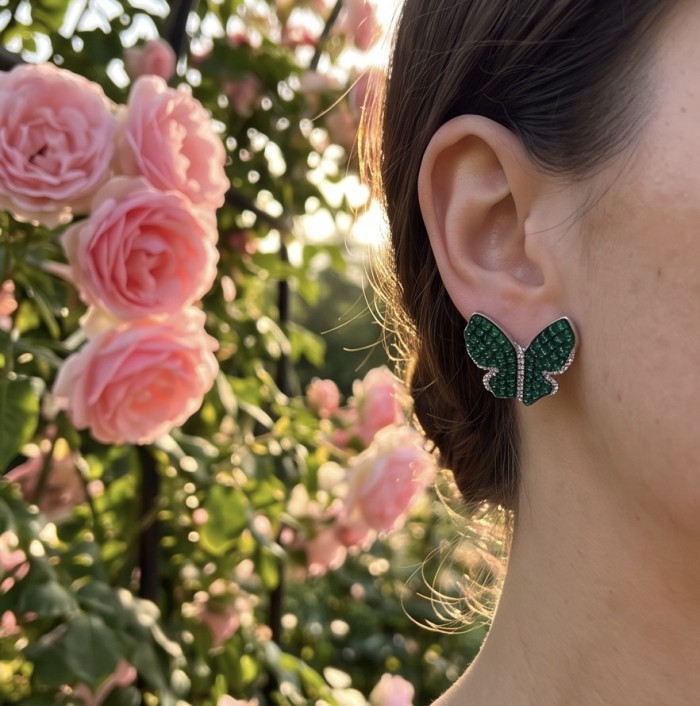 Incredible Butterflies genuine mystery setting 15.5 CARAT Emerald .925 Sterling Silver handcrafted Earrings - Green butterfly earrings worn, side view with pink roses background