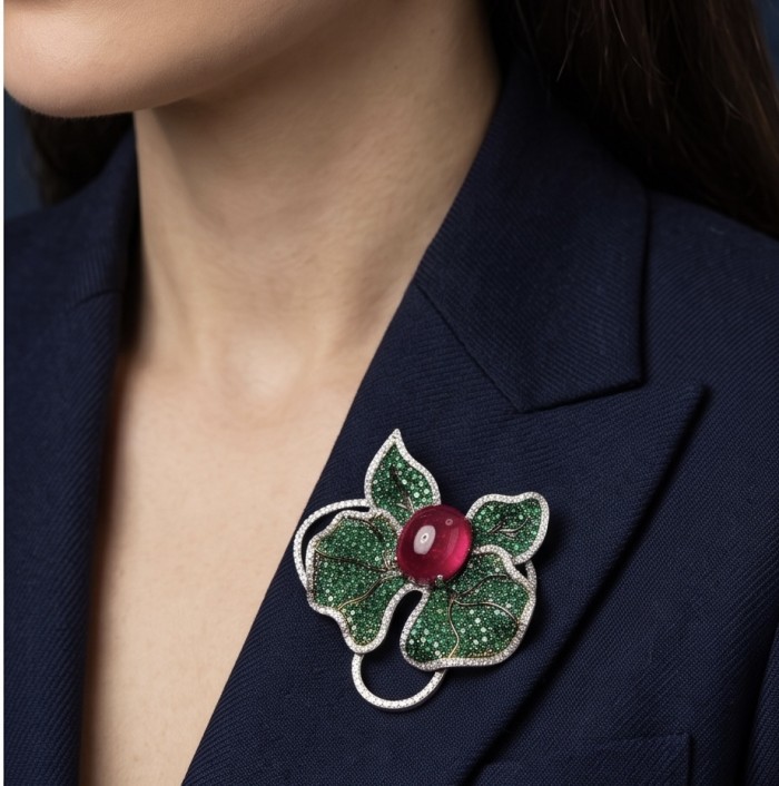 Giovanna - 18.5 carat Authentic Kashmir Ruby pave 4.2 carat Emerald .925 Sterling Silver handcrafted Pendant and Brooch - Ruby brooch with green leaves, worn on navy blazer, side view.