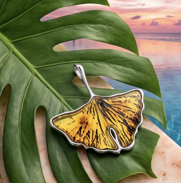 Calla Lily Prehistoric Authentic Butterscotch Baltic Amber .925 Sterling Silver beautifully handcrafted Pendant - Amber calla lily pendant on green leaf, sunset ocean backdrop.
