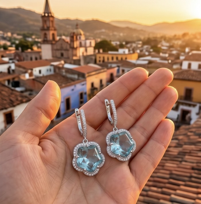 Rare Flower 9.8 carat GREEN GRANDIDIERITE .925 Sterling Silver Handcrafted Earrings - Earrings with green grandidierite held in hand, sunset town background