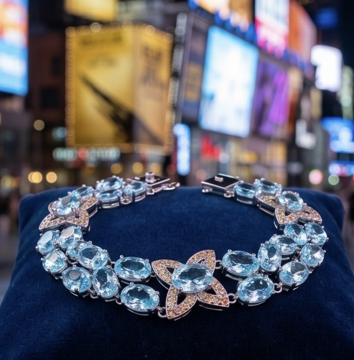 Tiffany - Magnificent 52.5 carat Swiss Blue Topaz .925 Sterling Silver handcrafted Statement Bracelet - Tiffany Blue Topaz necklace on display with a cityscape background.
