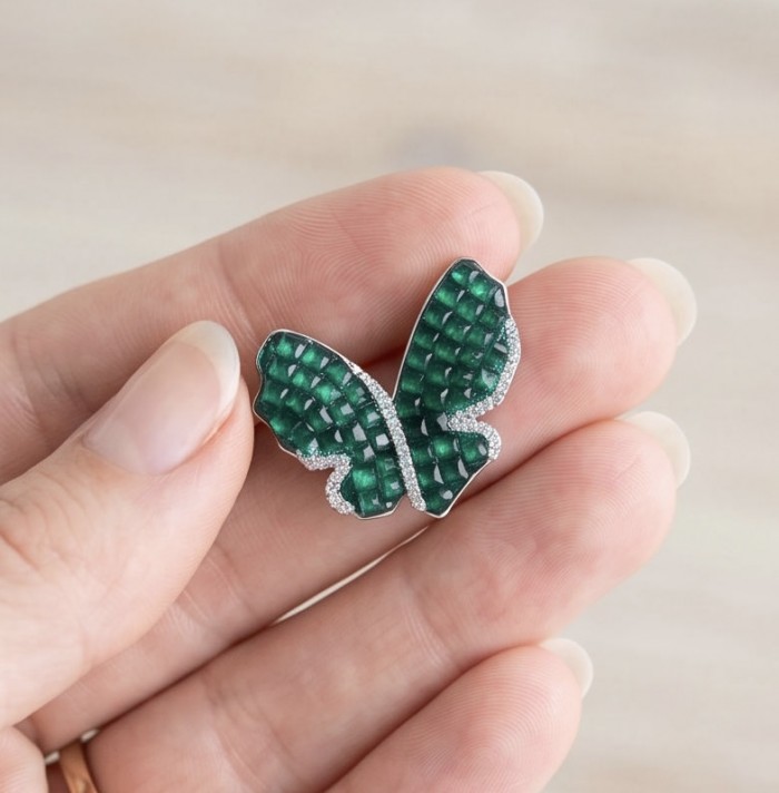 Incredible Butterflies genuine 15.5 CARAT Emerald .925 Sterling Silver handcrafted Earrings - Close-up of butterfly-shaped emerald jewelry held in hand