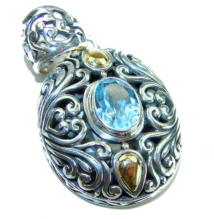 Atlantica oval cut 5.9 carat Swiss Blue Topaz 14K Gold over .925 Sterling Silver Handcrafted Pendant - Close-up of ornate pendant with blue topaz and intricate silver detailing.