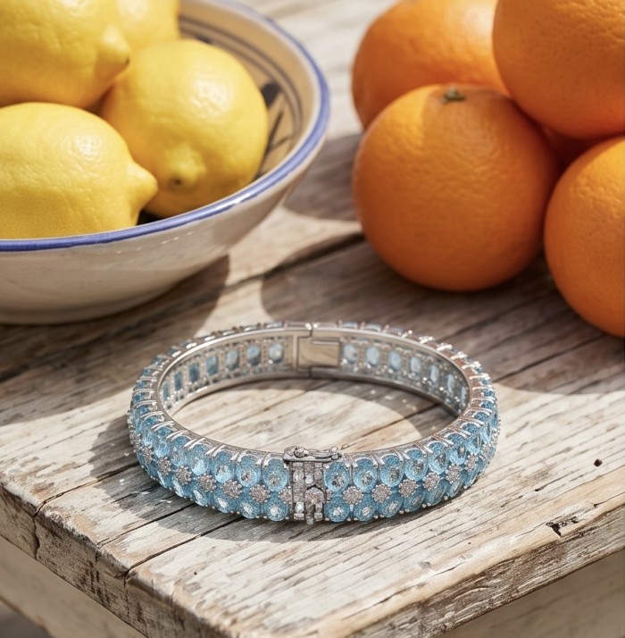 Serenity - Spectacular authentic 152.7 carat Swiss Blue Topaz .925 Sterling Silver handmade bangle Bracelet - Bracelet with blue topaz on rustic table with lemons and oranges.